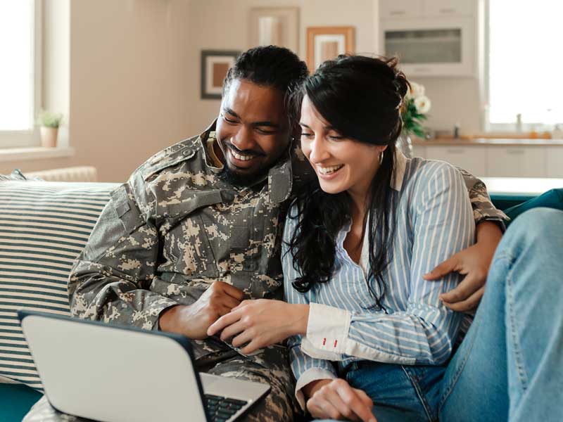 Military couple using laptop for attending virtual class